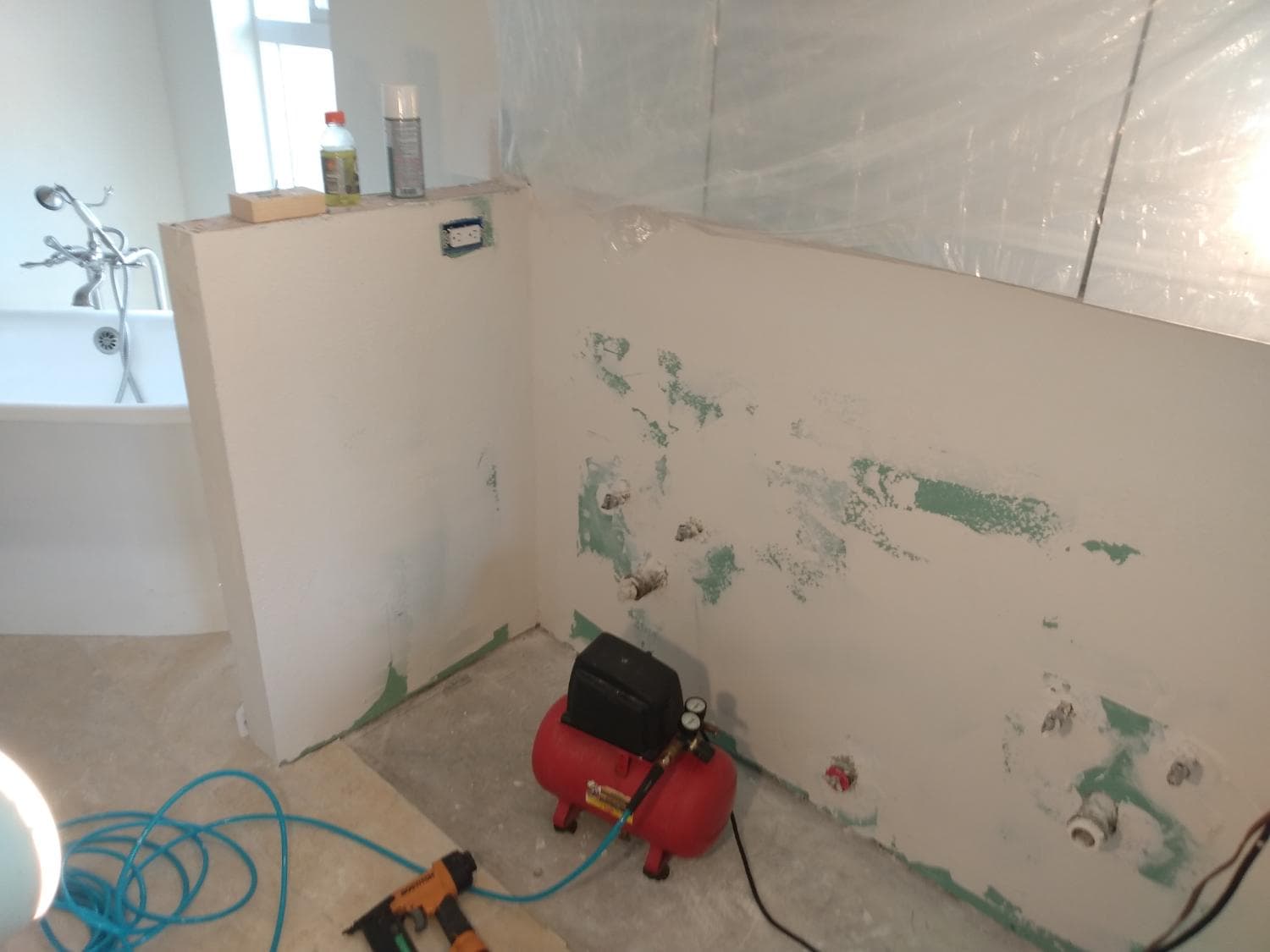 Greenboard drywall installed, tub set — ready for finish
